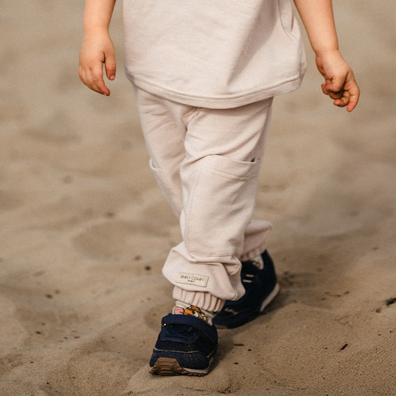 Eevi Simply Comfy beżowe – bawełniane spodnie dziecięce z kieszeniami i elastycznym pasem